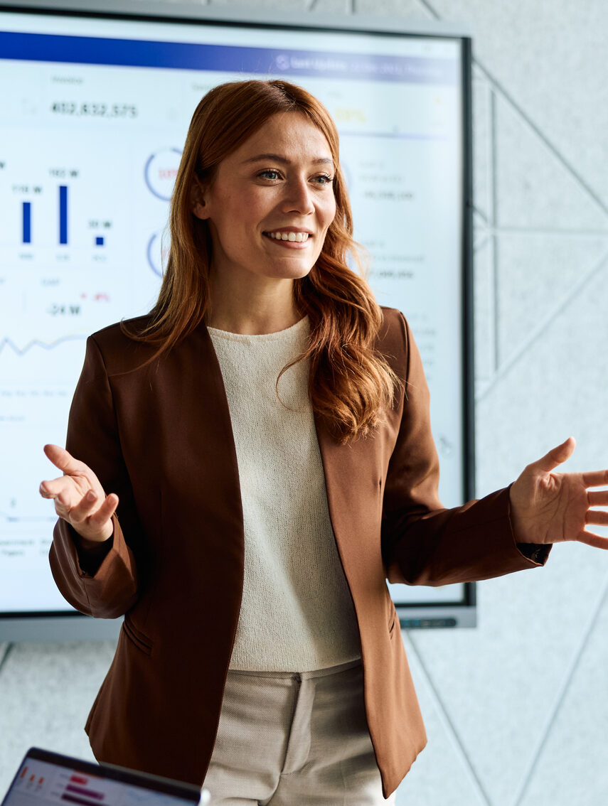 Woman Presenting Financial Data Dashboard In Business Meeting